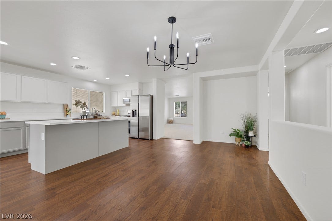 648 Moonlight Mesa Drive, Henderson, NV 89011 A well-lit kitchen with sleek stainless steel appliances, a generous island, and ample white cabinetry.