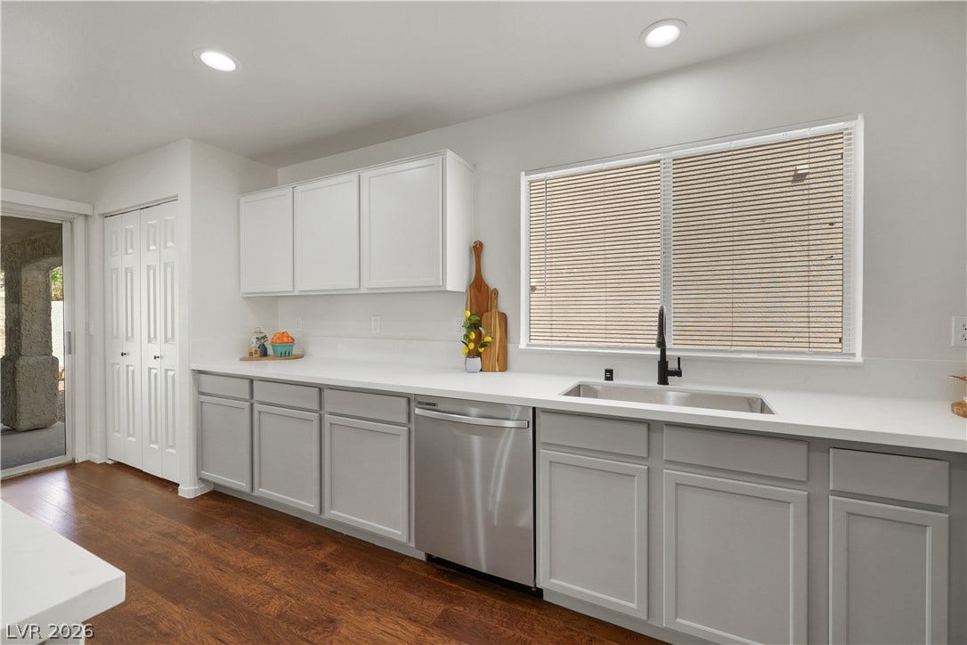 648 Moonlight Mesa Drive, Henderson, NV 89011 A well-appointed culinary space featuring ample white cabinetry, sleek countertops, and rich hardwood flooring.
