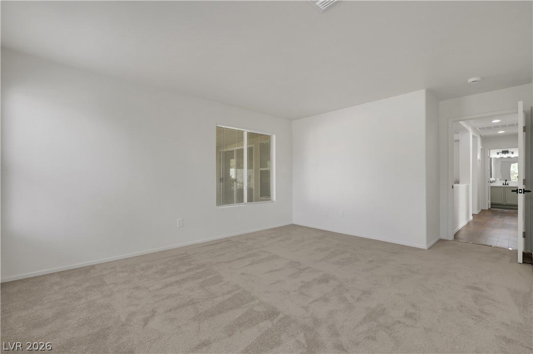 648 Moonlight Mesa Drive, Henderson, NV 89011 A quiet living area offers a neutral palette, awaiting your personal touch.