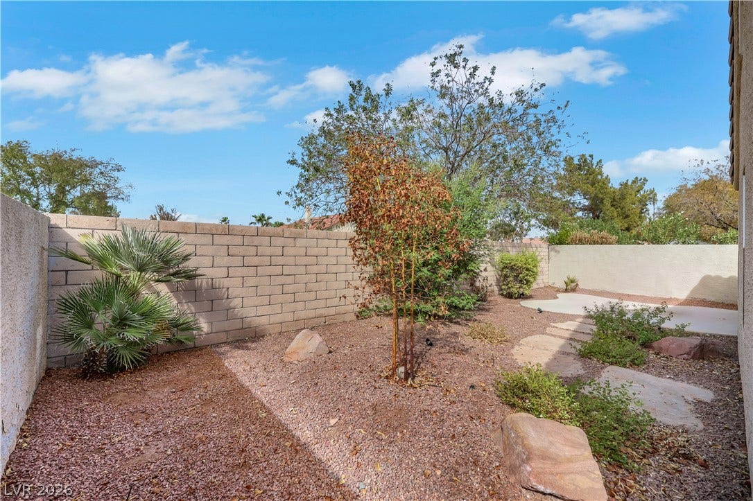 648 Moonlight Mesa Drive, Henderson, NV 89011 A desert-inspired landscape with natural rock elements and verdant plantings provides a tranquil backyard escape.