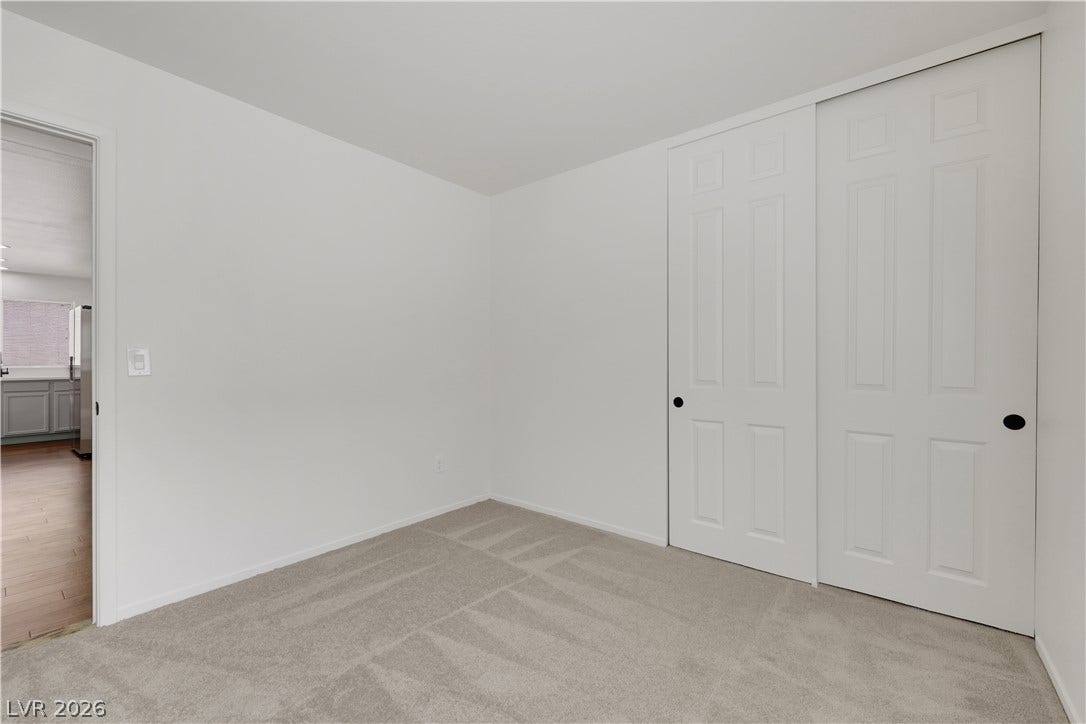 648 Moonlight Mesa Drive, Henderson, NV 89011 A spacious room offers ample storage with large, paneled closet doors and plush carpeting.