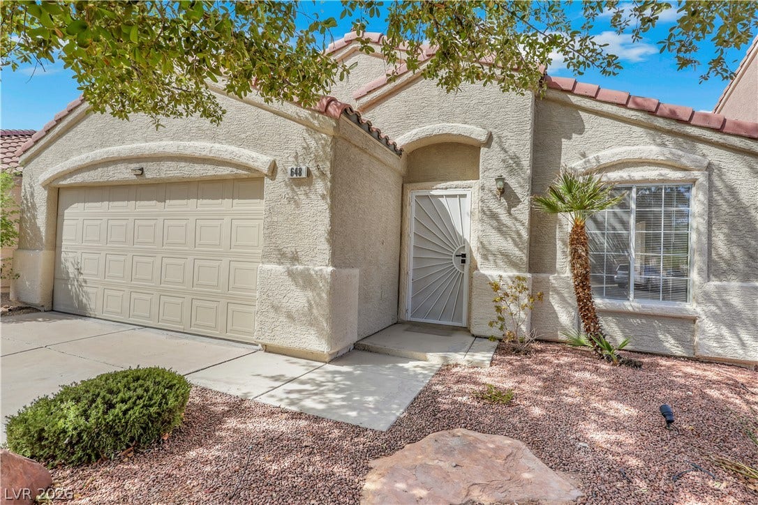 648 Moonlight Mesa Drive, Henderson, NV 89011 A well-maintained stucco facade with a convenient attached garage and desert landscaping welcomes you home.
