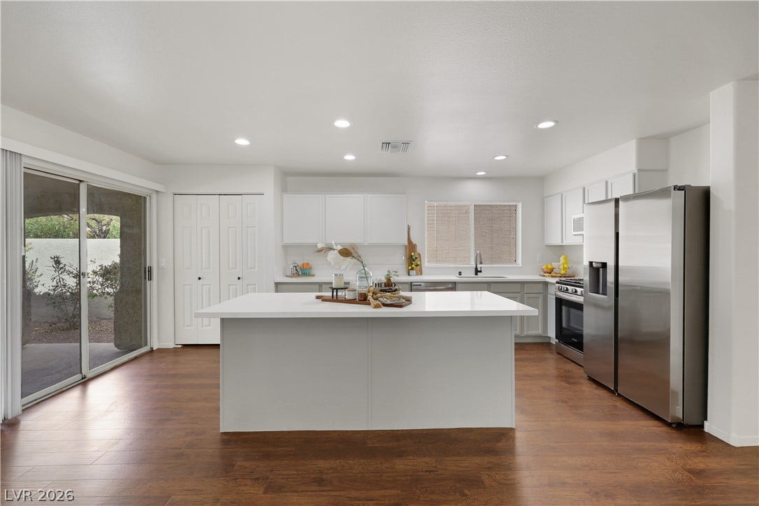 648 Moonlight Mesa Drive, Henderson, NV 89011 An inviting kitchen with rich hardwood flooring and a large island, perfect for culinary endeavors and gatherings.