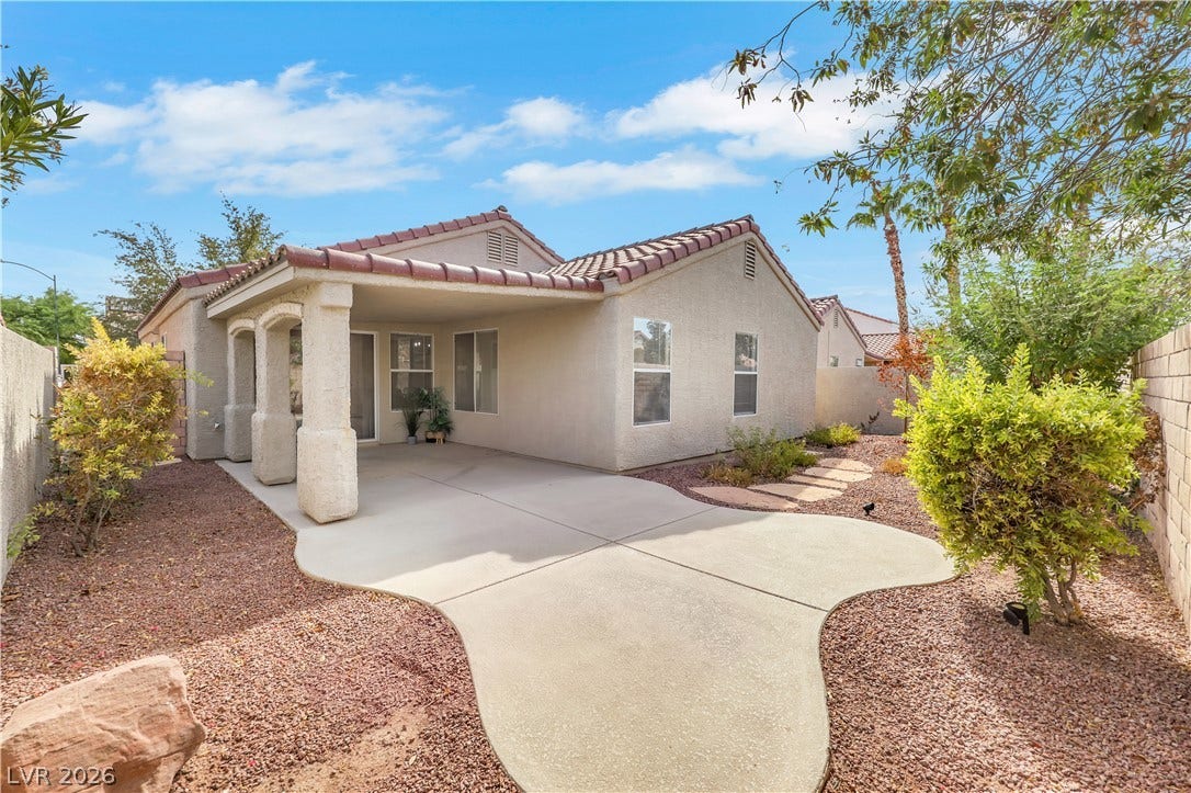 648 Moonlight Mesa Drive, Henderson, NV 89011 A terracotta-tiled roof crowns this residence, featuring a covered patio and a winding pathway.
