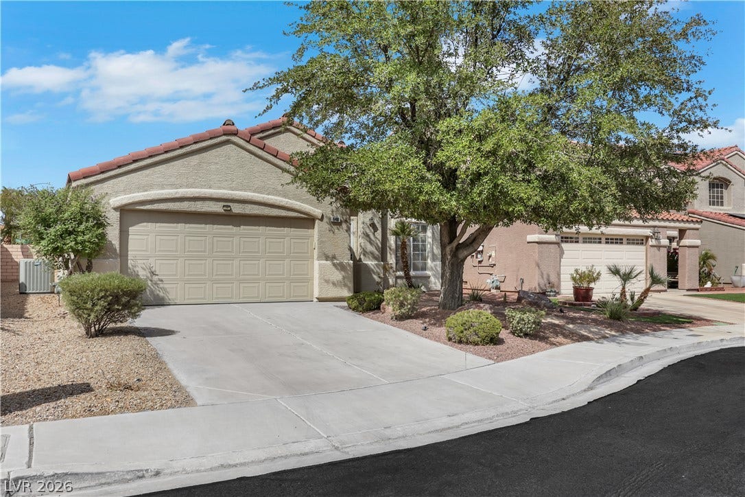 648 Moonlight Mesa Drive, Henderson, NV 89011 A well-maintained stucco home with an attached garage and mature landscaping offers inviting curb appeal.