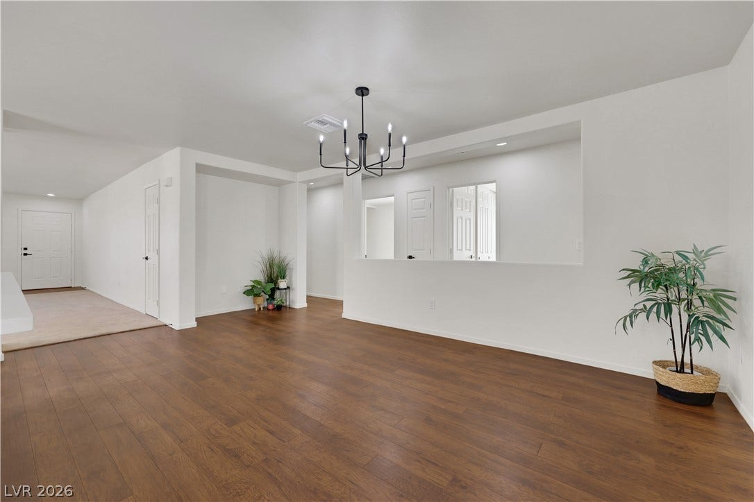 648 Moonlight Mesa Drive, Henderson, NV 89011 Rich hardwood floors flow through this open-concept space, illuminated by a contemporary chandelier.