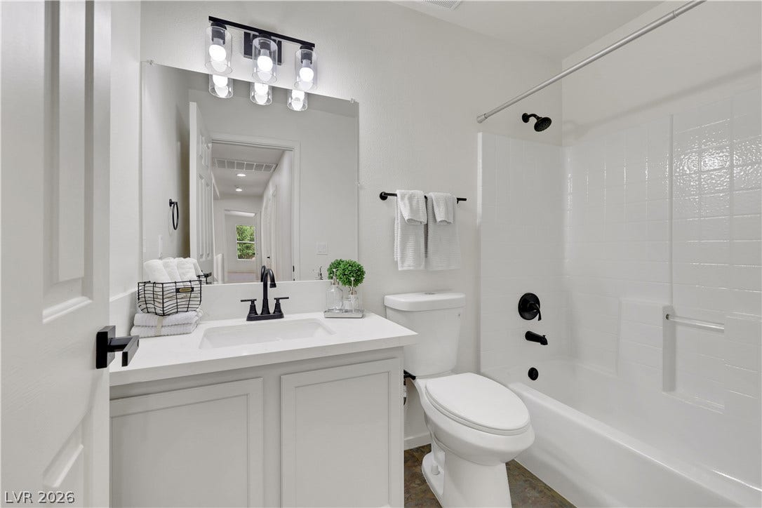 648 Moonlight Mesa Drive, Henderson, NV 89011 A pristine bathroom featuring a sleek vanity with contemporary fixtures and a bright, tiled shower-tub combo.