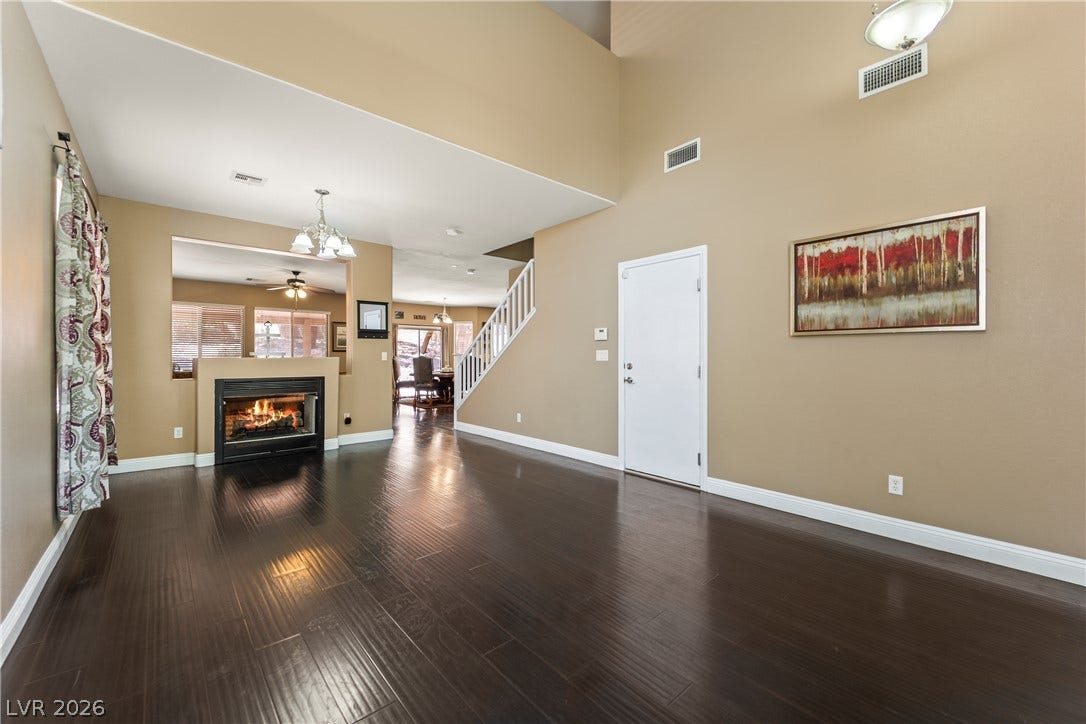 7337 Picnic Hill Street, Las Vegas, NV 89166 Rich Laminate flooring guides you through this inviting living space, accented by a cozy fireplace and soaring ceiling.