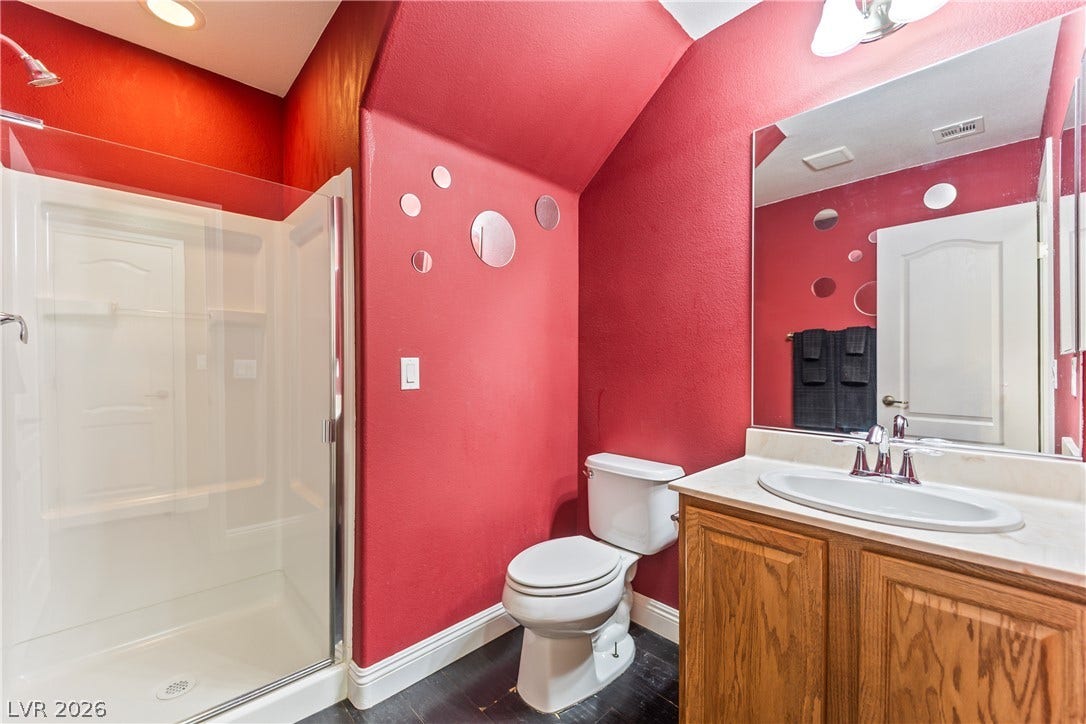 7337 Picnic Hill Street, Las Vegas, NV 89166 A vibrant bathroom with a shower stall, wood vanity, and ample lighting offers a refreshing space.