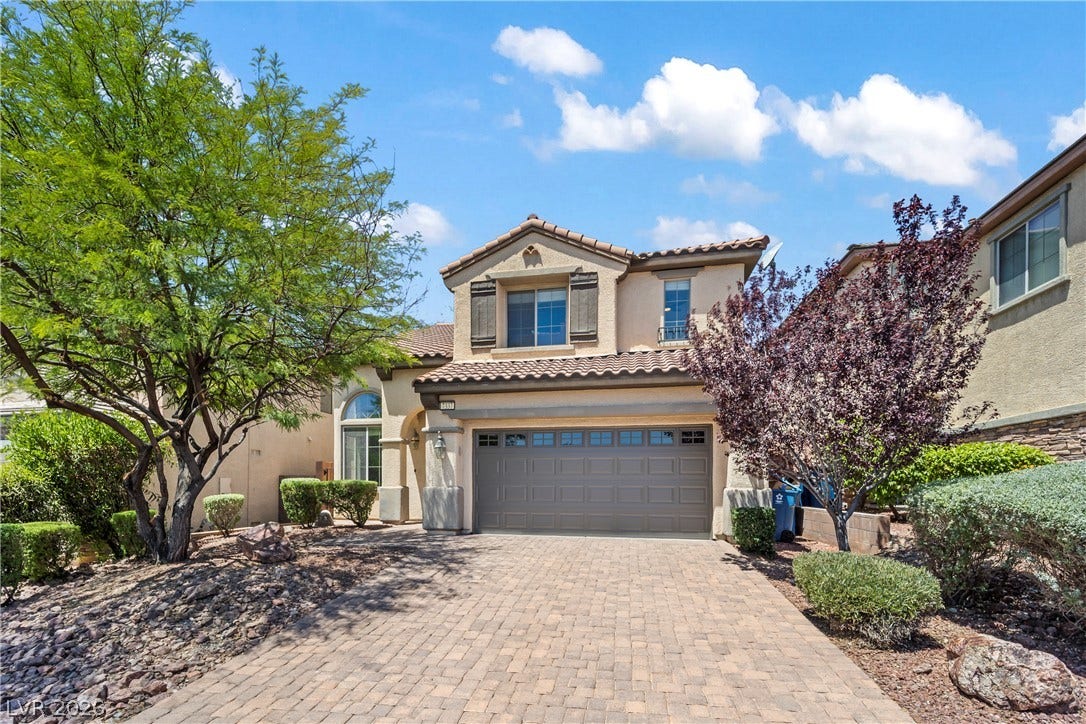 7337 Picnic Hill Street, Las Vegas, NV 89166 A welcoming front exterior featuring a paver driveway, an attached garage, and mature landscaping.