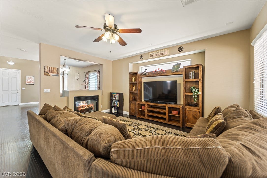 7337 Picnic Hill Street, Las Vegas, NV 89166 A welcoming living area boasts dark hardwood floors, a cozy fireplace