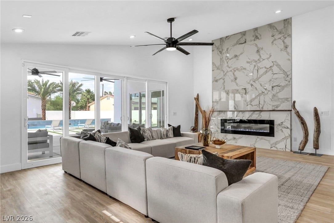 3630 Tobias Lane, Las Vegas, NV 89120 A refined living area boasts an impressive fireplace wall and direct access to outdoor living through sliding glass doors.