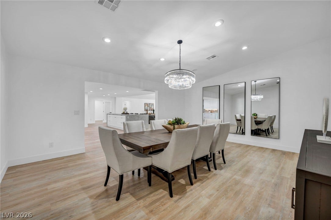 3630 Tobias Lane, Las Vegas, NV 89120 A sophisticated dining area features a grand chandelier and modern recessed lighting, perfect for entertaining.