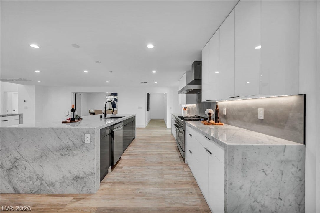 3630 Tobias Lane, Las Vegas, NV 89120 Culinary dreams come alive in this kitchen, featuring an extended island with a sleek sink and high-gloss cabinetry.