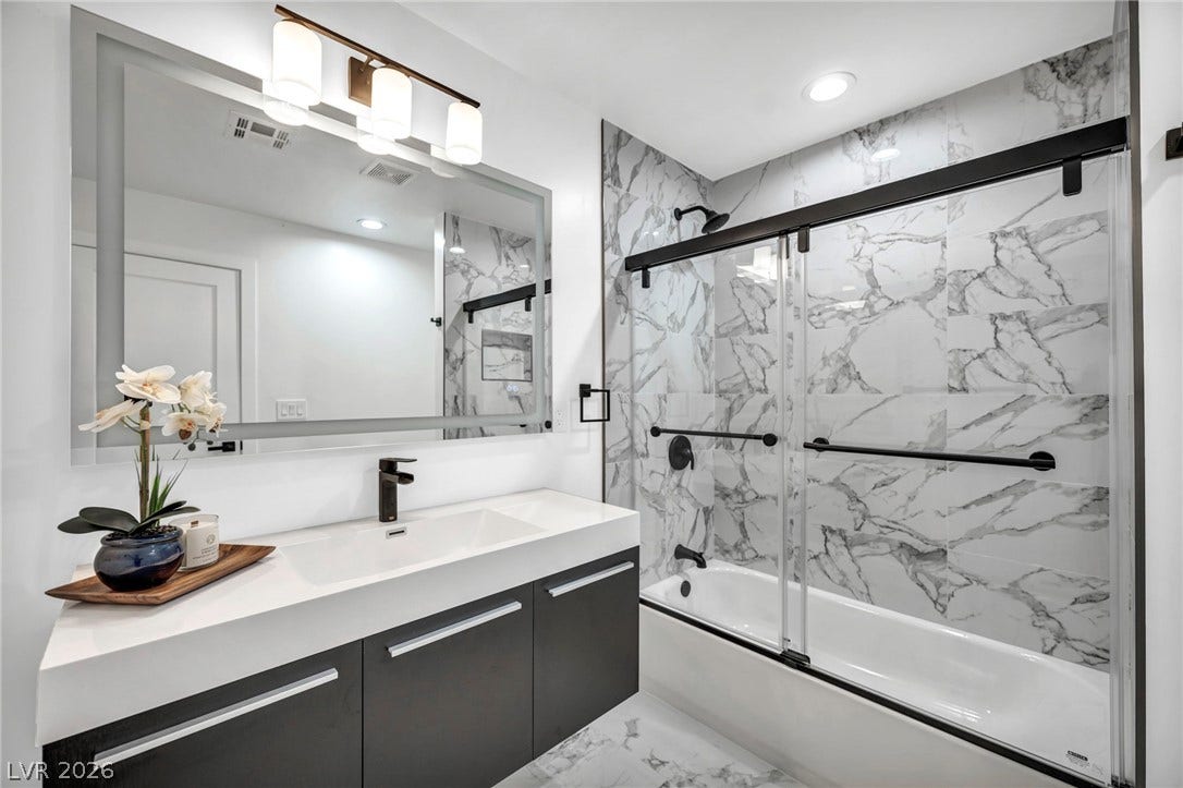 3630 Tobias Lane, Las Vegas, NV 89120 A well-appointed bath features a contemporary vanity and a tub with a sleek glass enclosure.