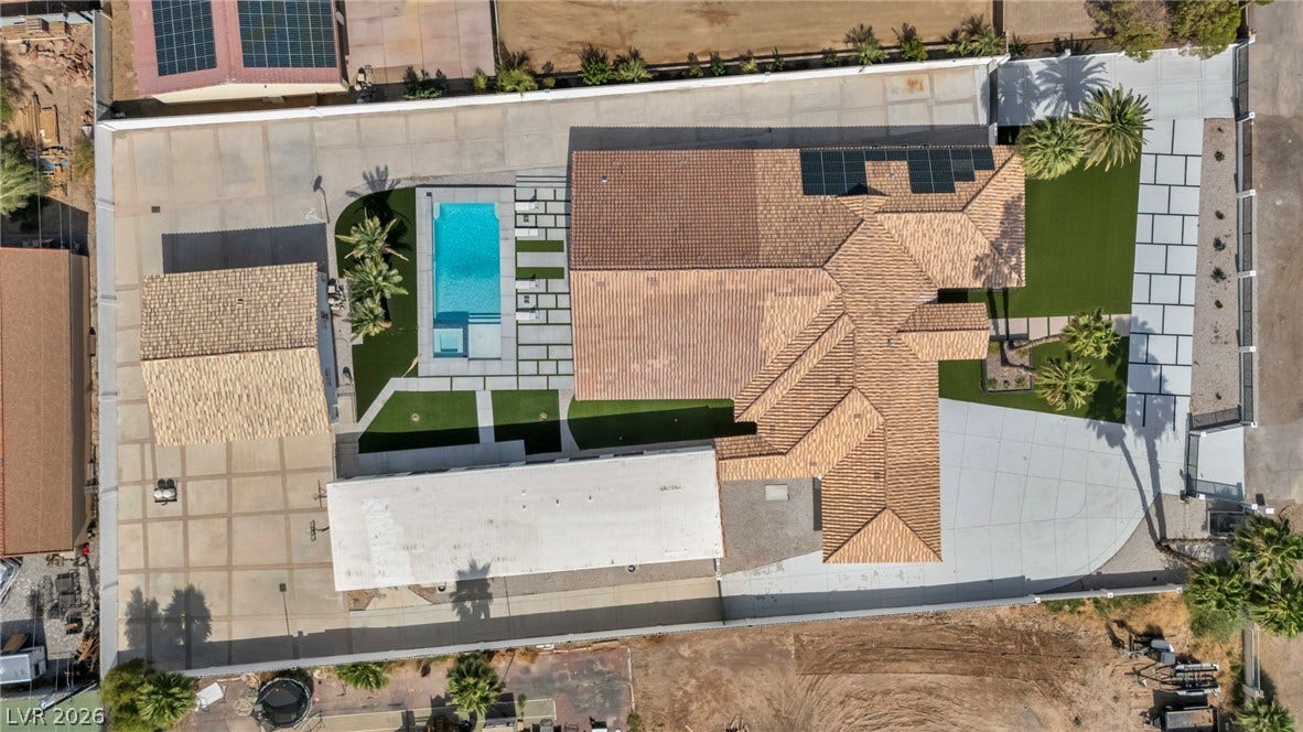 3630 Tobias Lane, Las Vegas, NV 89120 An aerial perspective reveals a luxurious home with a sparkling pool, manicured lawns, and expansive paved areas.