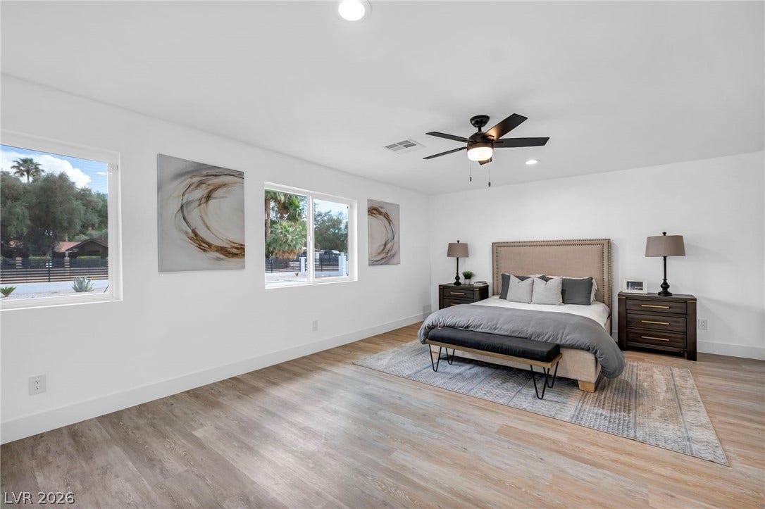 3630 Tobias Lane, Las Vegas, NV 89120 Sun-filled primary bedroom with sleek flooring and modern ceiling fan creates a serene retreat.