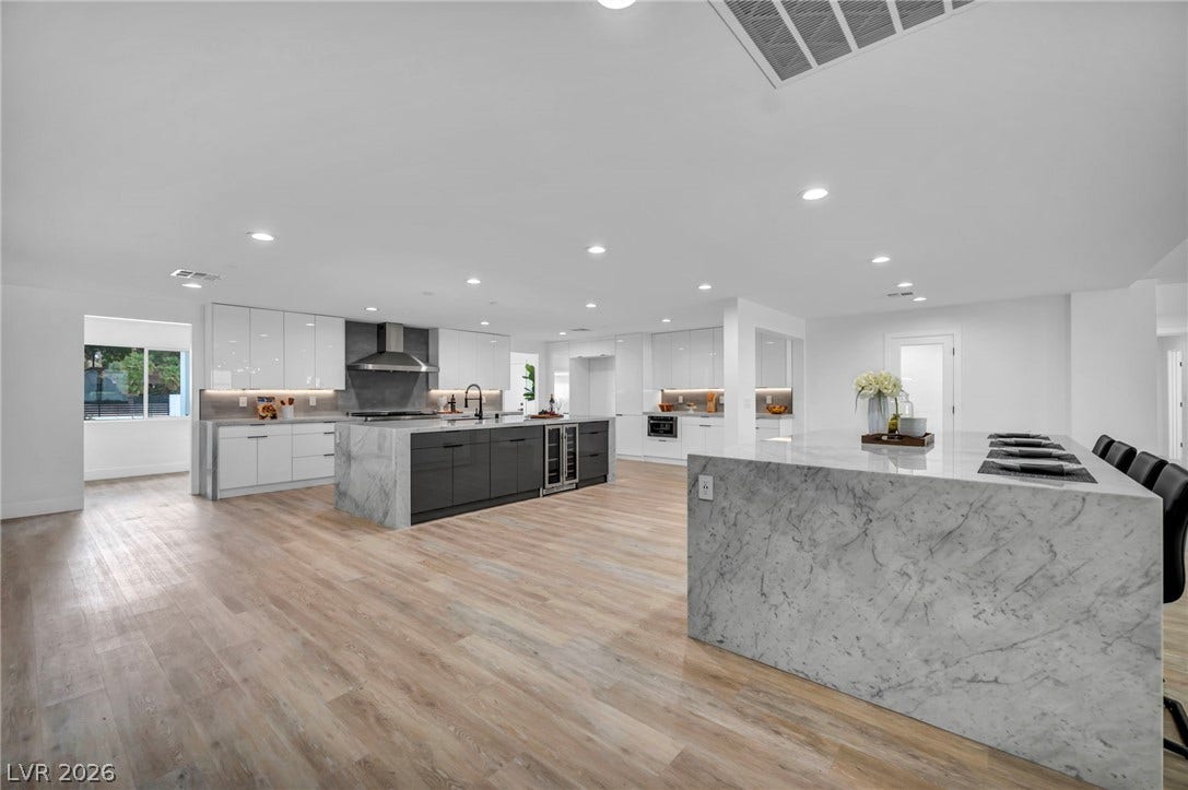 3630 Tobias Lane, Las Vegas, NV 89120 Culinary excellence awaits in this well-appointed kitchen, featuring a spacious island and gleaming wood flooring.