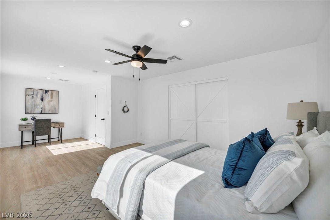 3630 Tobias Lane, Las Vegas, NV 89120 A well-lit bedroom with modern wood-style flooring features a functional workspace.