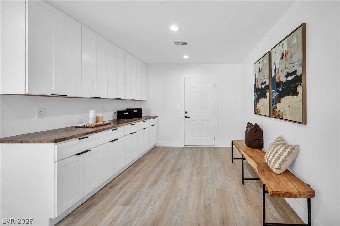 3630 Tobias Lane, Las Vegas, NV 89120 A well-lit, naturally illuminated room features abundant white cabinetry, warm wood countertops, and modern flooring.