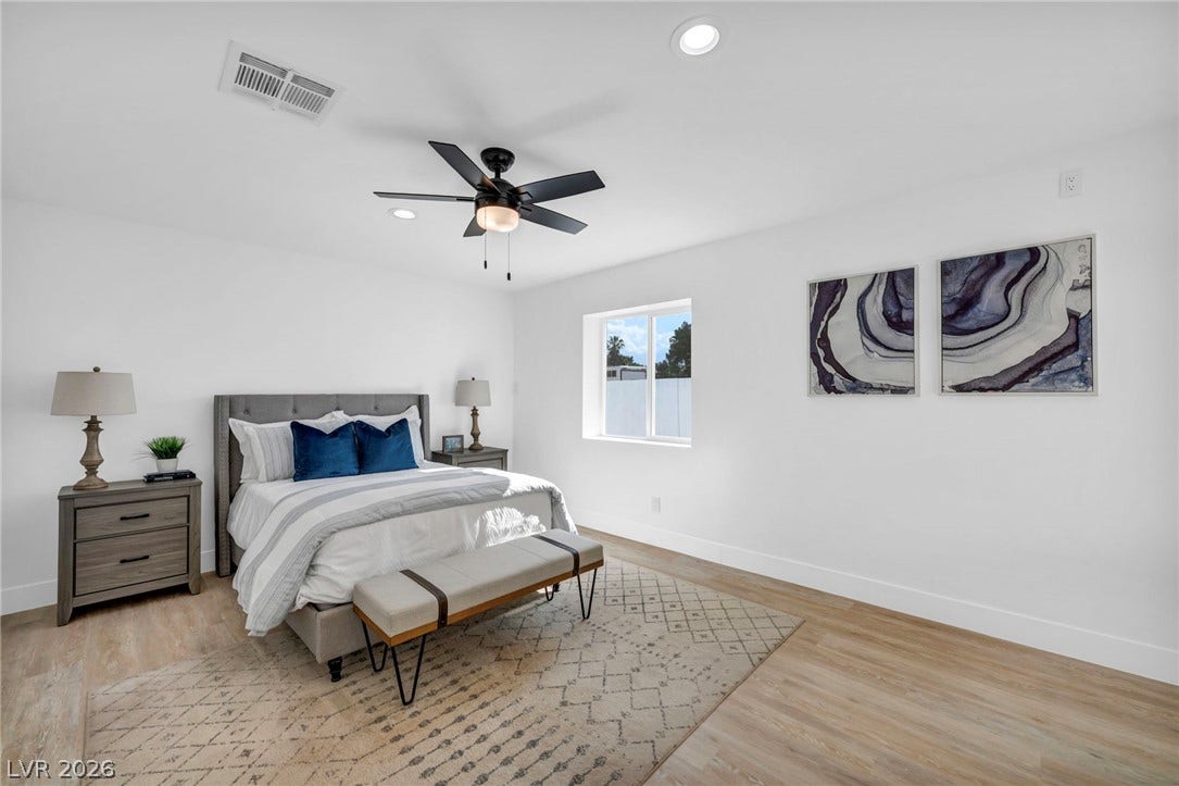 3630 Tobias Lane, Las Vegas, NV 89120 Relax in a generously sized primary bedroom featuring light wood flooring and a modern ceiling fan.