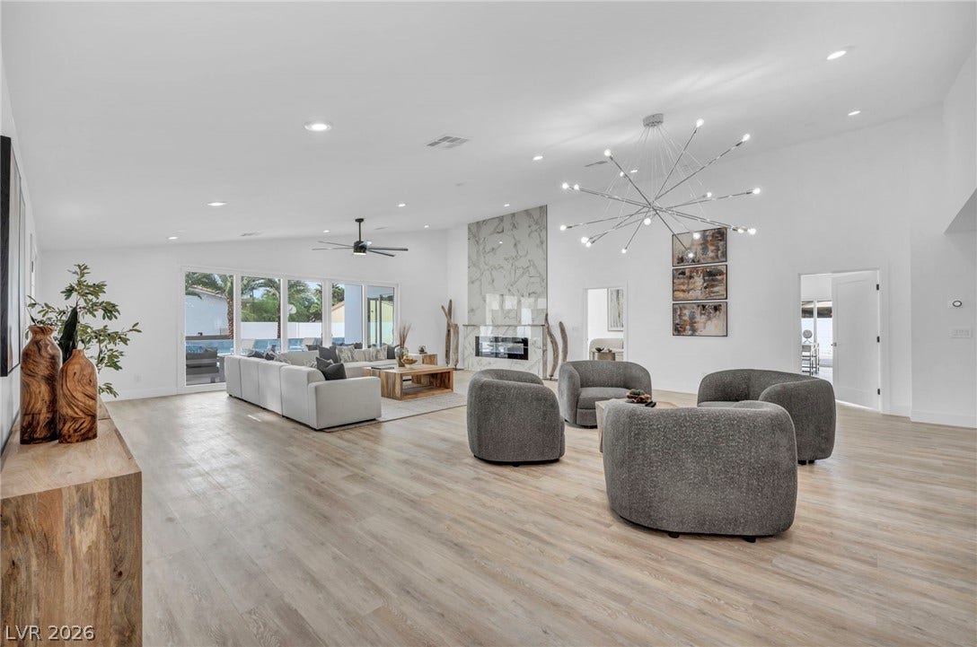 3630 Tobias Lane, Las Vegas, NV 89120 An airy living area offers abundant natural illumination, a captivating fireplace, and direct access to an outdoor oasis.