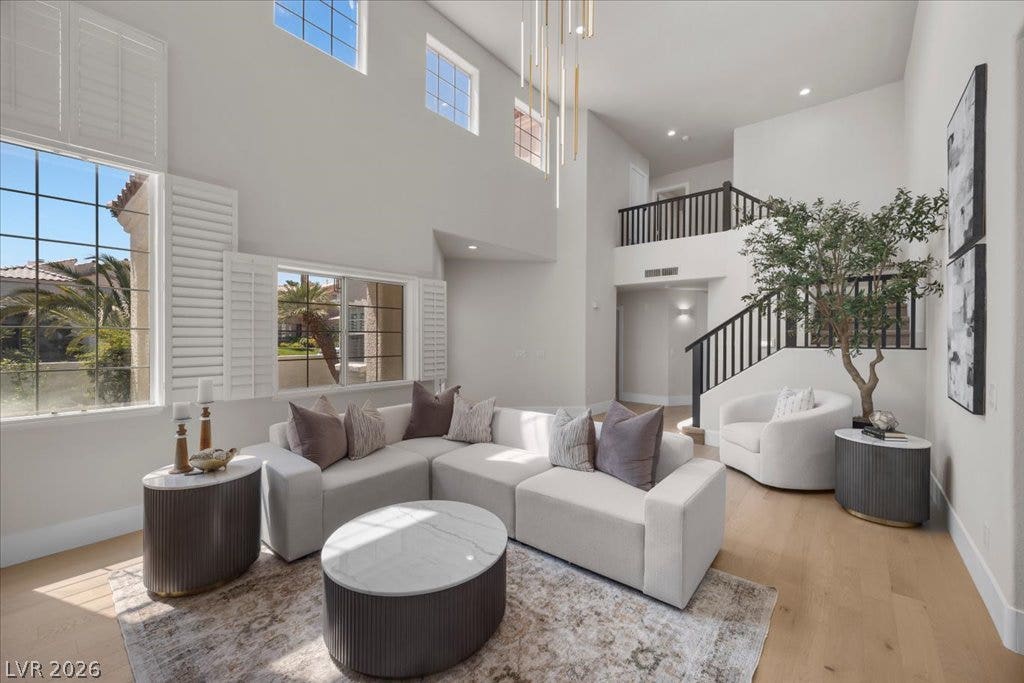 8024 Shorecrest Drive, Las Vegas, NV 89128 Sun-filled living area features soaring high ceilings, expansive windows, and durable hardwood flooring.