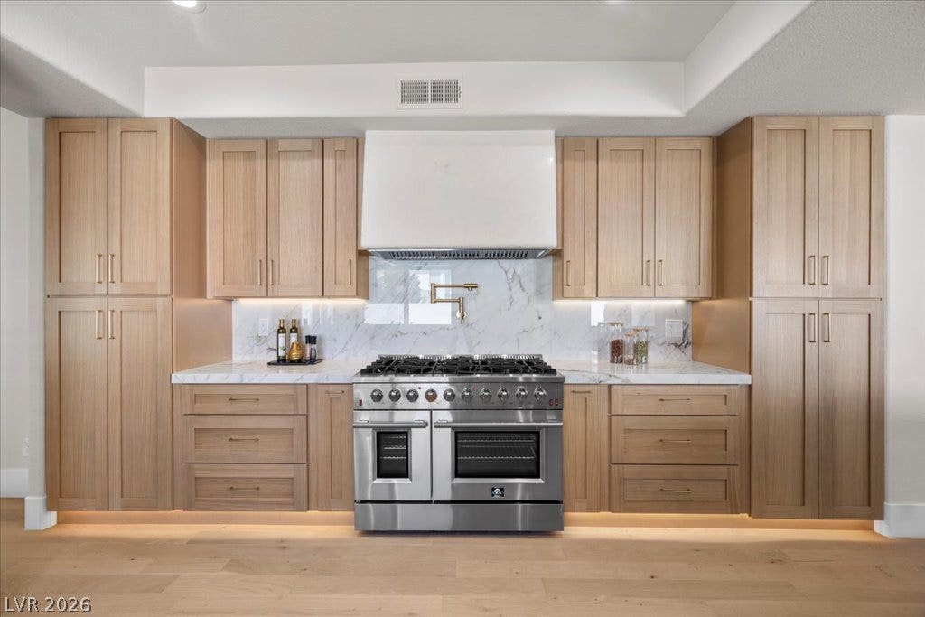 8024 Shorecrest Drive, Las Vegas, NV 89128 Culinary adventures await in this kitchen, featuring natural wood cabinetry and a professional-grade range.