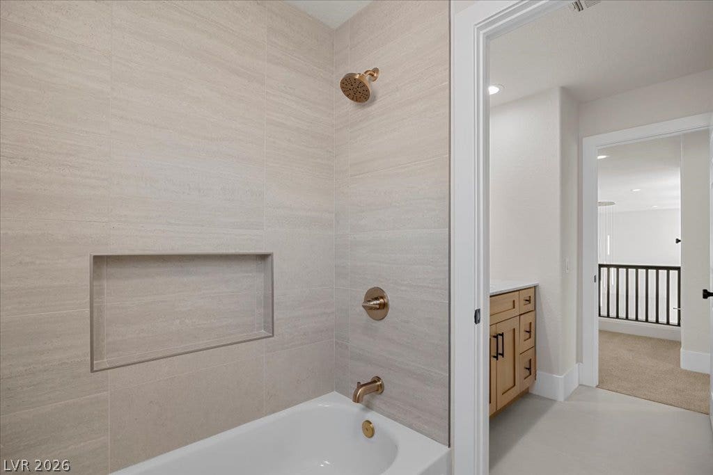 8024 Shorecrest Drive, Las Vegas, NV 89128 A well-appointed bathroom features a bathtub and shower with brass fixtures and a built-in shower niche.
