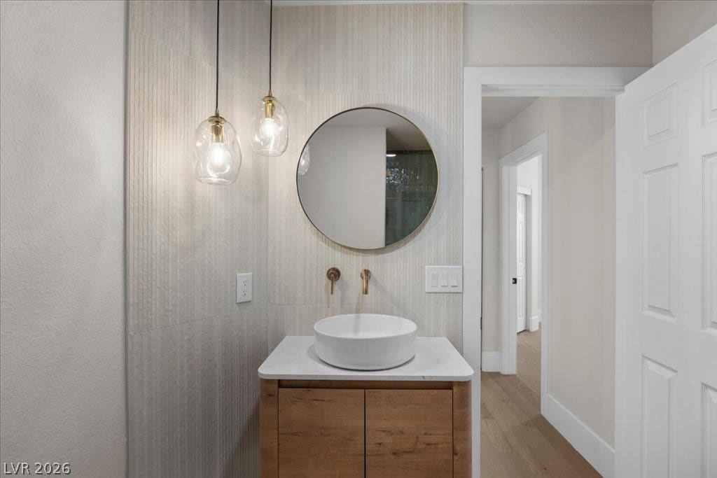 8024 Shorecrest Drive, Las Vegas, NV 89128 A stylish half bath features a vessel sink, warm wood vanity, and contemporary lighting.