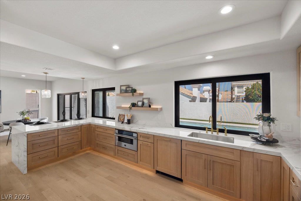 8024 Shorecrest Drive, Las Vegas, NV 89128 A well-appointed kitchen features rich wooden cabinetry, gleaming countertops, and an integrated oven, ideal for culinary creations.