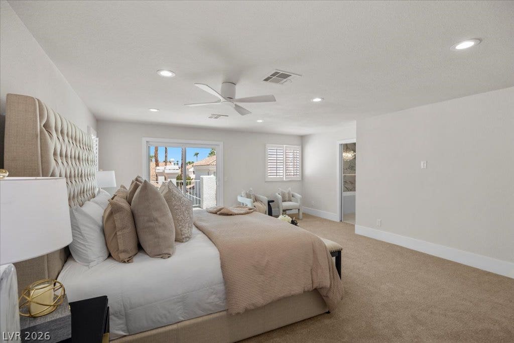 8024 Shorecrest Drive, Las Vegas, NV 89128 A spacious primary suite features a private balcony access, soft carpeting, and recessed lighting.