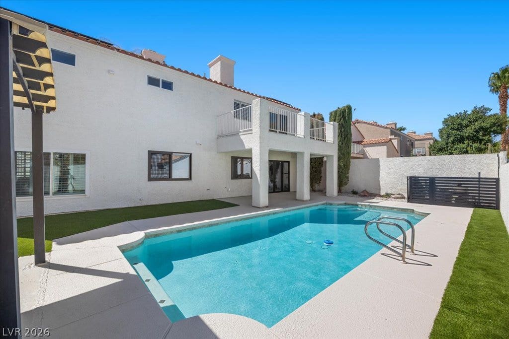 8024 Shorecrest Drive, Las Vegas, NV 89128 An inviting backyard oasis offers a pristine swimming pool and a private upper-level balcony for relaxed outdoor living.