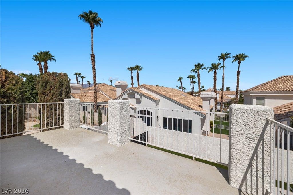 8024 Shorecrest Drive, Las Vegas, NV 89128 A spacious rooftop patio overlooks a neighborhood of charming homes with terracotta roofs and towering palm trees.
