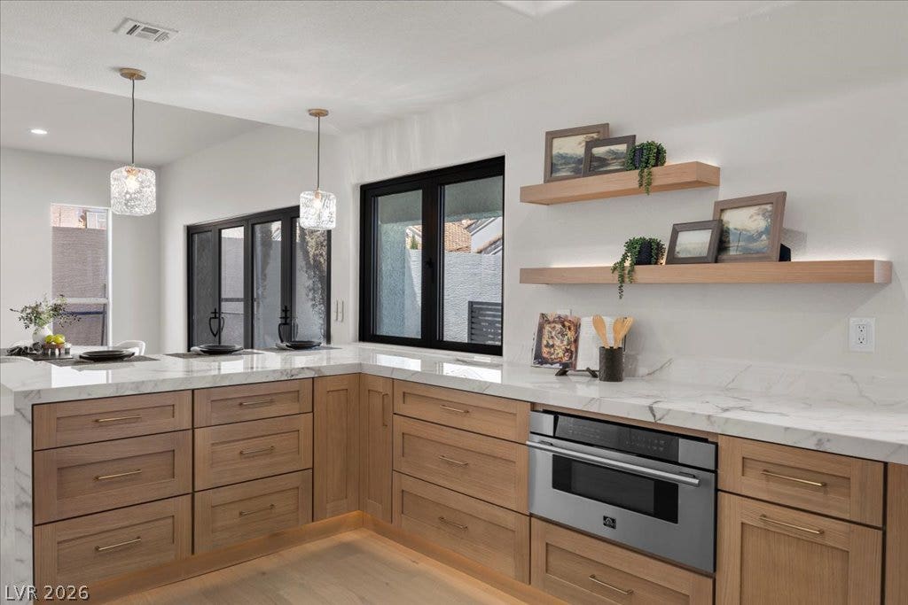 8024 Shorecrest Drive, Las Vegas, NV 89128 A well-appointed kitchen features marble countertops, custom cabinetry, and modern built-in appliances.