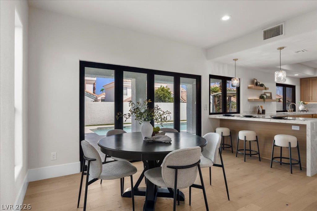 8024 Shorecrest Drive, Las Vegas, NV 89128 Sliding glass doors offer an airy transition from the dining space to the inviting outdoor pool.