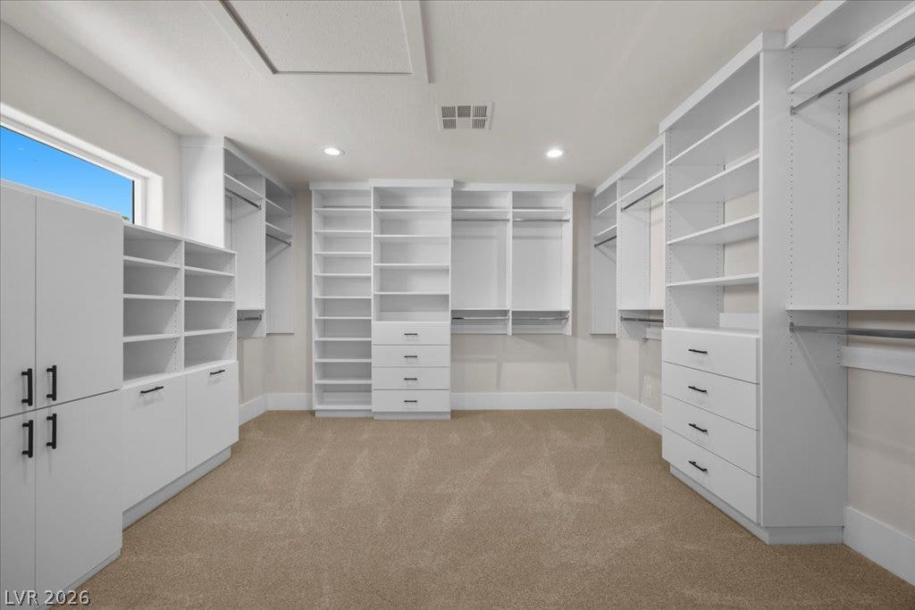 8024 Shorecrest Drive, Las Vegas, NV 89128 Custom shelving and hanging rods create an organized dressing area in this well-lit walk-in closet.