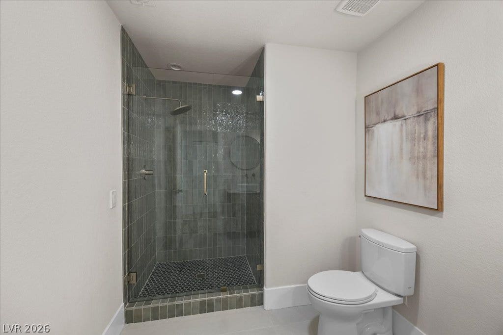 8024 Shorecrest Drive, Las Vegas, NV 89128 A well-appointed bathroom features a spacious walk-in shower with sleek glass enclosure and a practical toilet.