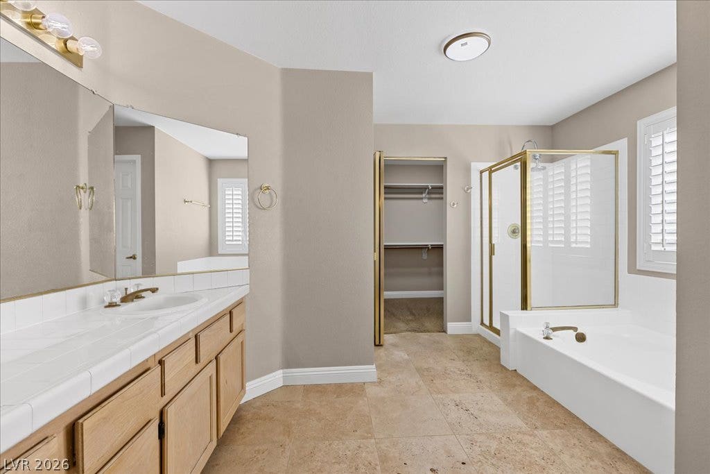 2000 Silverton Drive, Henderson, NV 89074 A primary bathroom featuring a spacious vanity with dual sinks, a large soaking tub, and an enclosed shower stall, providing ample space for relaxation.
