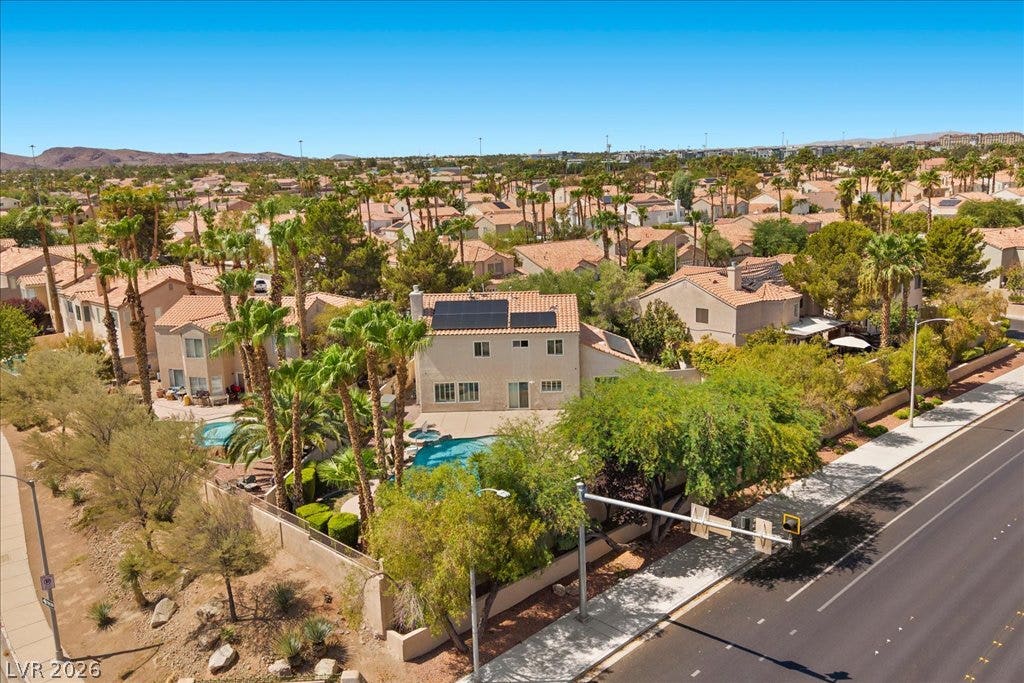 2000 Silverton Drive, Henderson, NV 89074 An aerial perspective reveals a private yard with a refreshing pool, nestled among palm trees and residential rooftops.