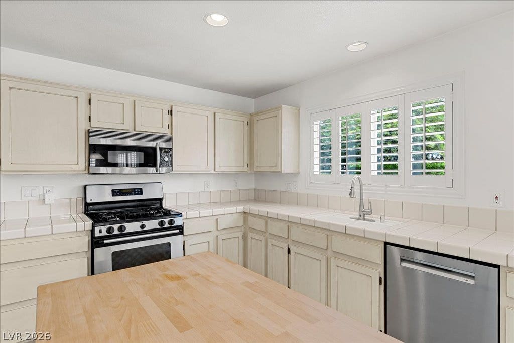 2000 Silverton Drive, Henderson, NV 89074 Culinary space featuring bright tile countertops and stainless steel appliances with an overhead microwave.