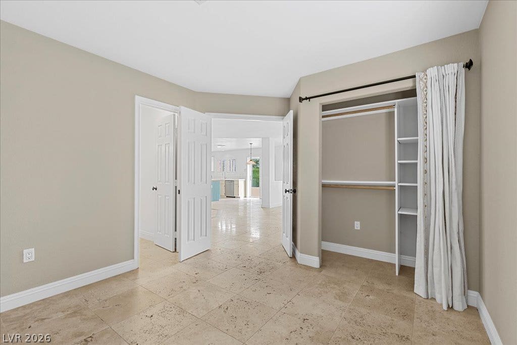 2000 Silverton Drive, Henderson, NV 89074 Functional bedroom featuring tile flooring and an open closet system with shelving and hanging space.