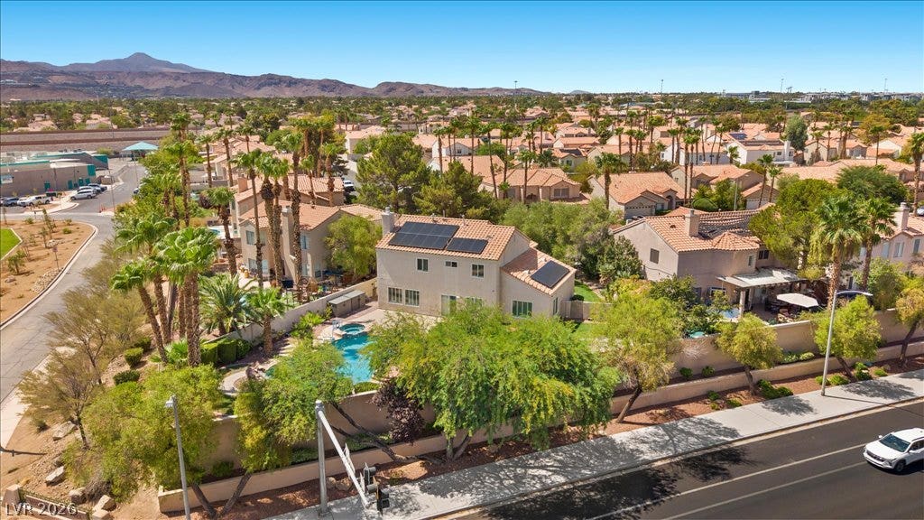 2000 Silverton Drive, Henderson, NV 89074 An aerial perspective reveals a private pool with solar panels, nestled among lush landscaping within a vibrant community.