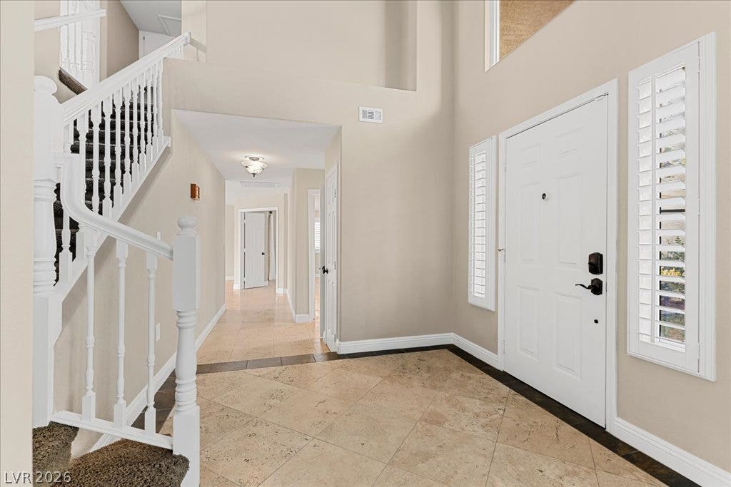 2000 Silverton Drive, Henderson, NV 89074 A spacious entry foyer greets visitors, featuring a graceful staircase and classic tiled flooring.
