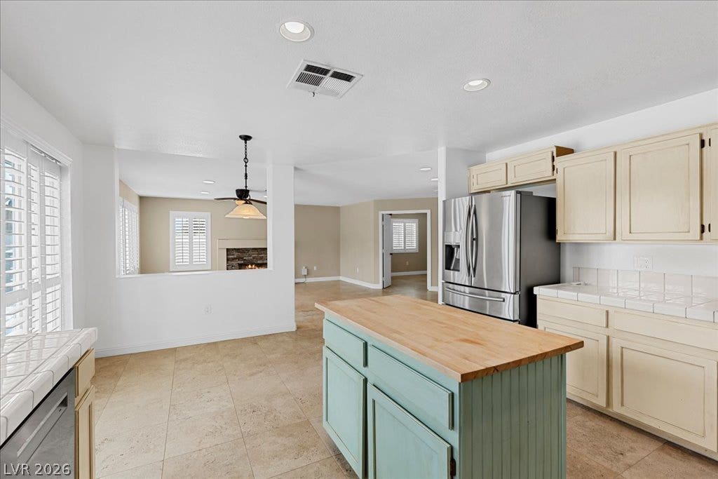 2000 Silverton Drive, Henderson, NV 89074 An open concept kitchen features stainless steel appliances and a butcher block island, flowing into the living area.