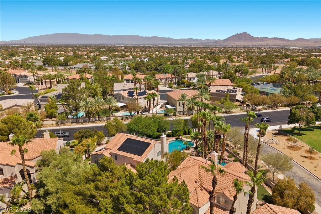 2000 Silverton Drive, Henderson, NV 89074 An aerial panorama reveals a vast residential community with pools, mature trees, and distant mountains under a clear sky.