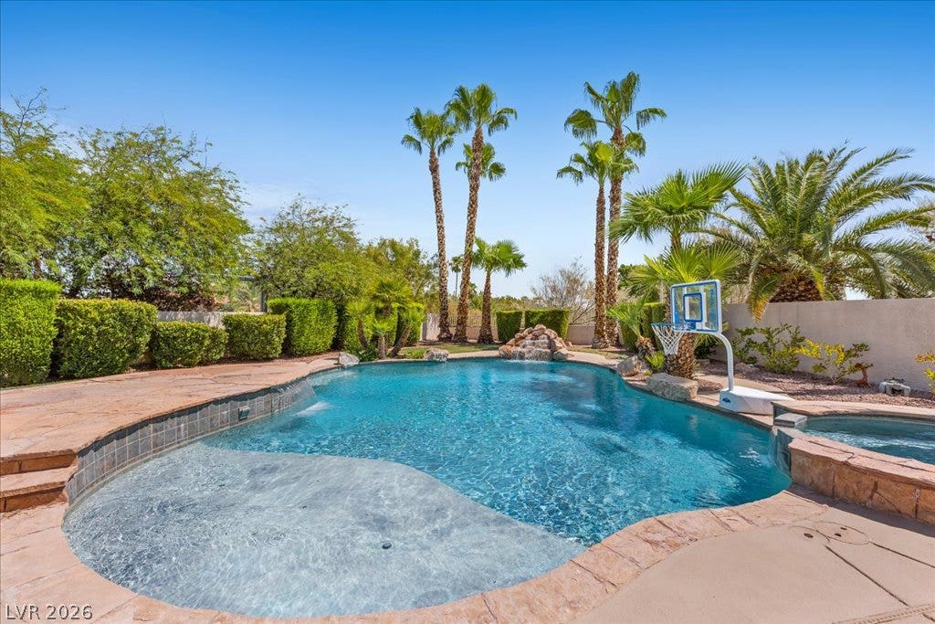 2000 Silverton Drive, Henderson, NV 89074 A tranquil oasis awaits, with a freeform pool, cascading waterfall, and mature palm trees.