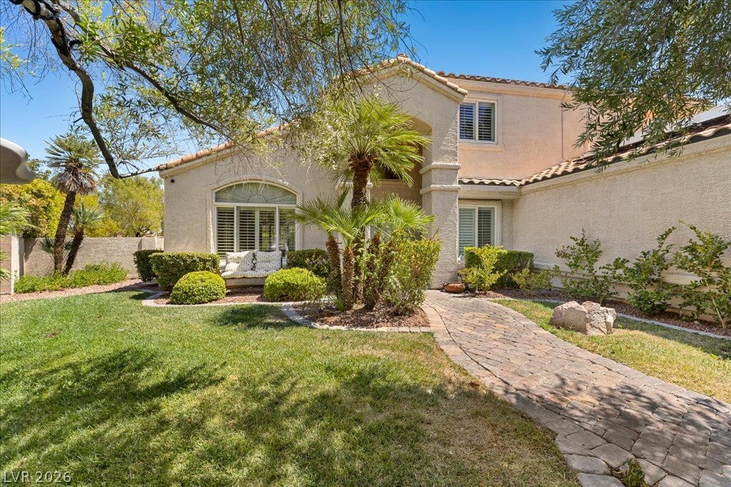 2000 Silverton Drive, Henderson, NV 89074 An inviting facade featuring a stone pathway leading to a well-maintained front entrance, surrounded by verdant landscaping.
