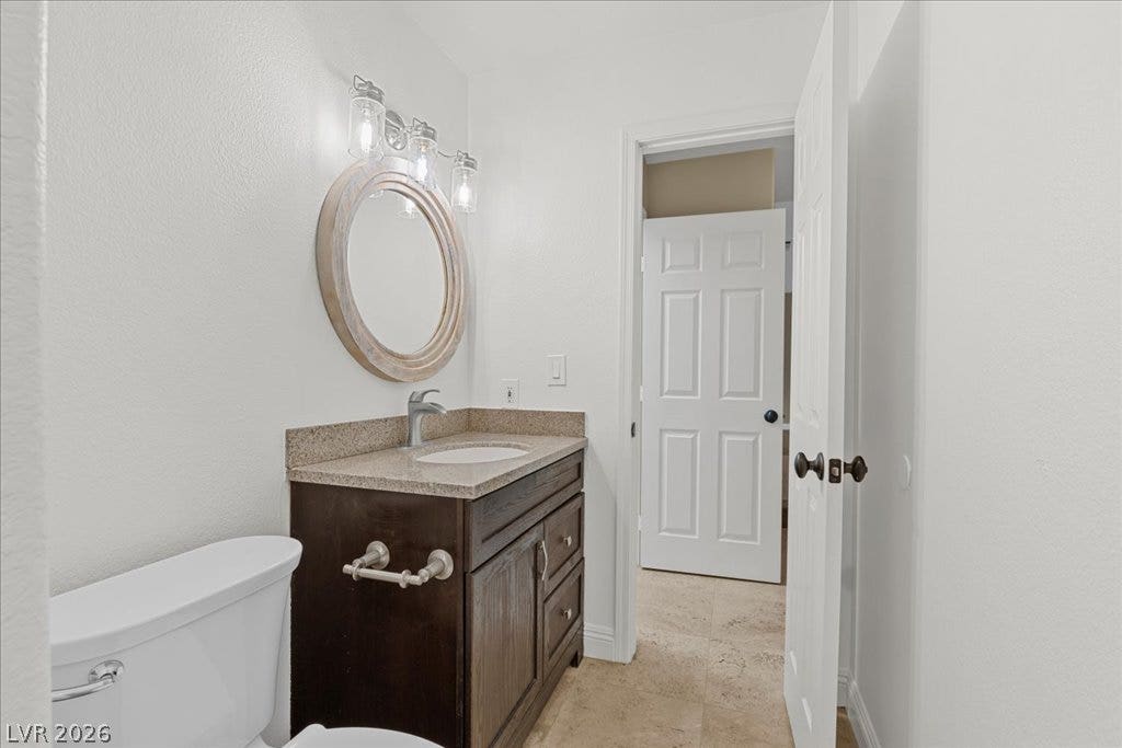2000 Silverton Drive, Henderson, NV 89074 A compact full bath, featuring a sleek vanity and convenient commode, designed for modern living.