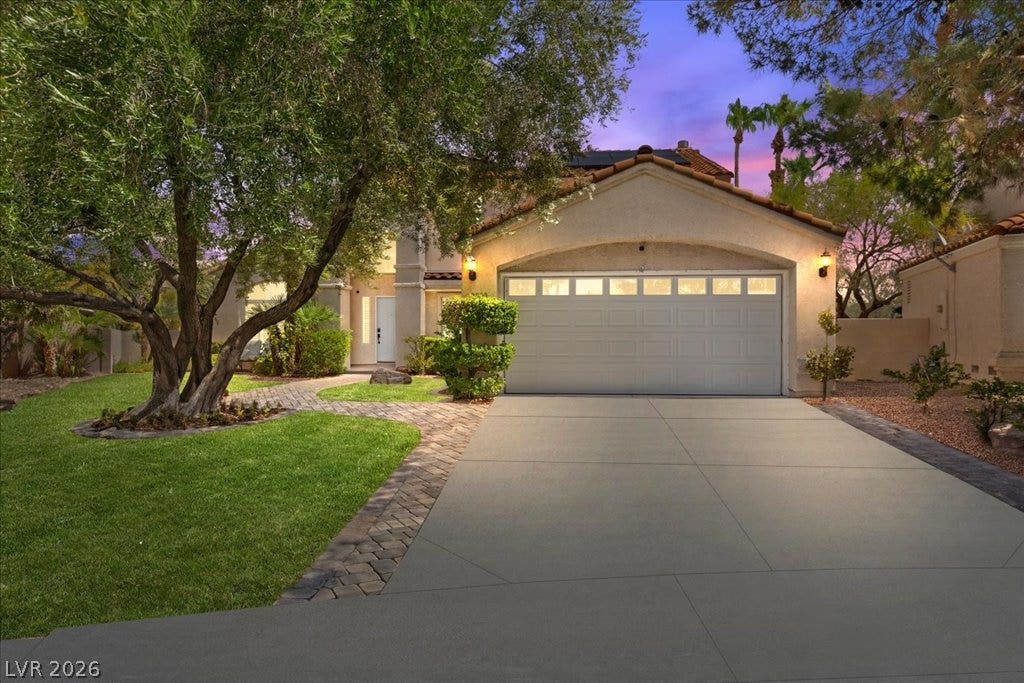 2000 Silverton Drive, Henderson, NV 89074 A well-kept front yard and driveway lead to this appealing single-family residence, bathed in the twilight glow.
